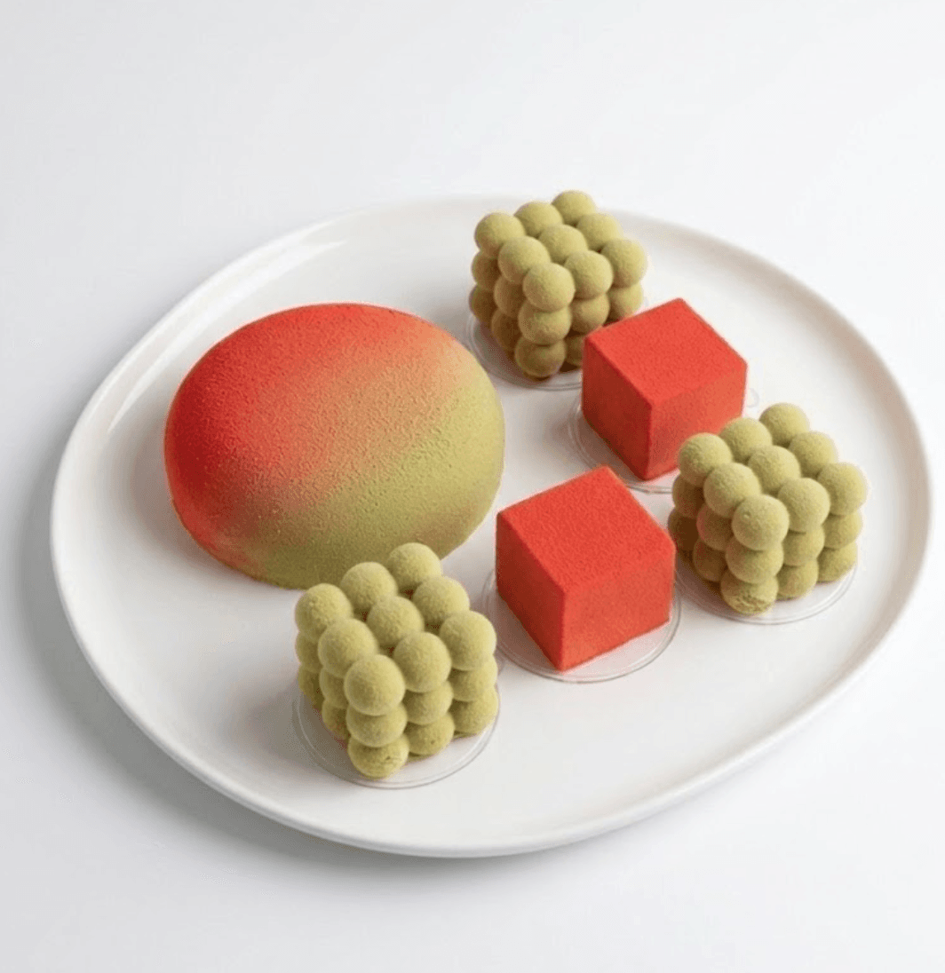 Pistachio and red geometric mousse desserts — signature design